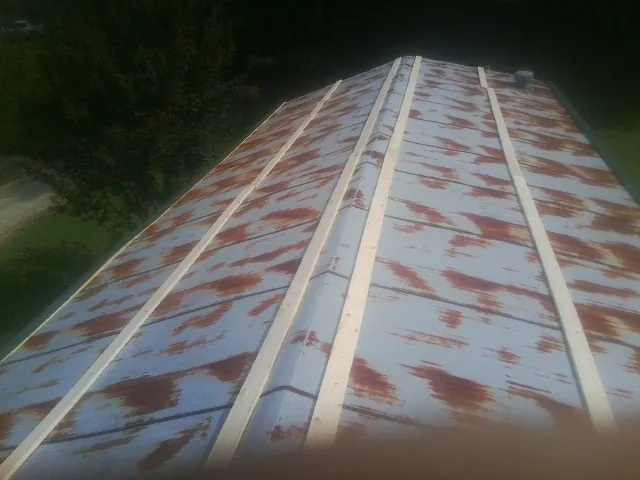 Rusted metal roof panels with new wood purlins before replacement — Storm Damage Roof Repair in Rockton by Roofing Brothers